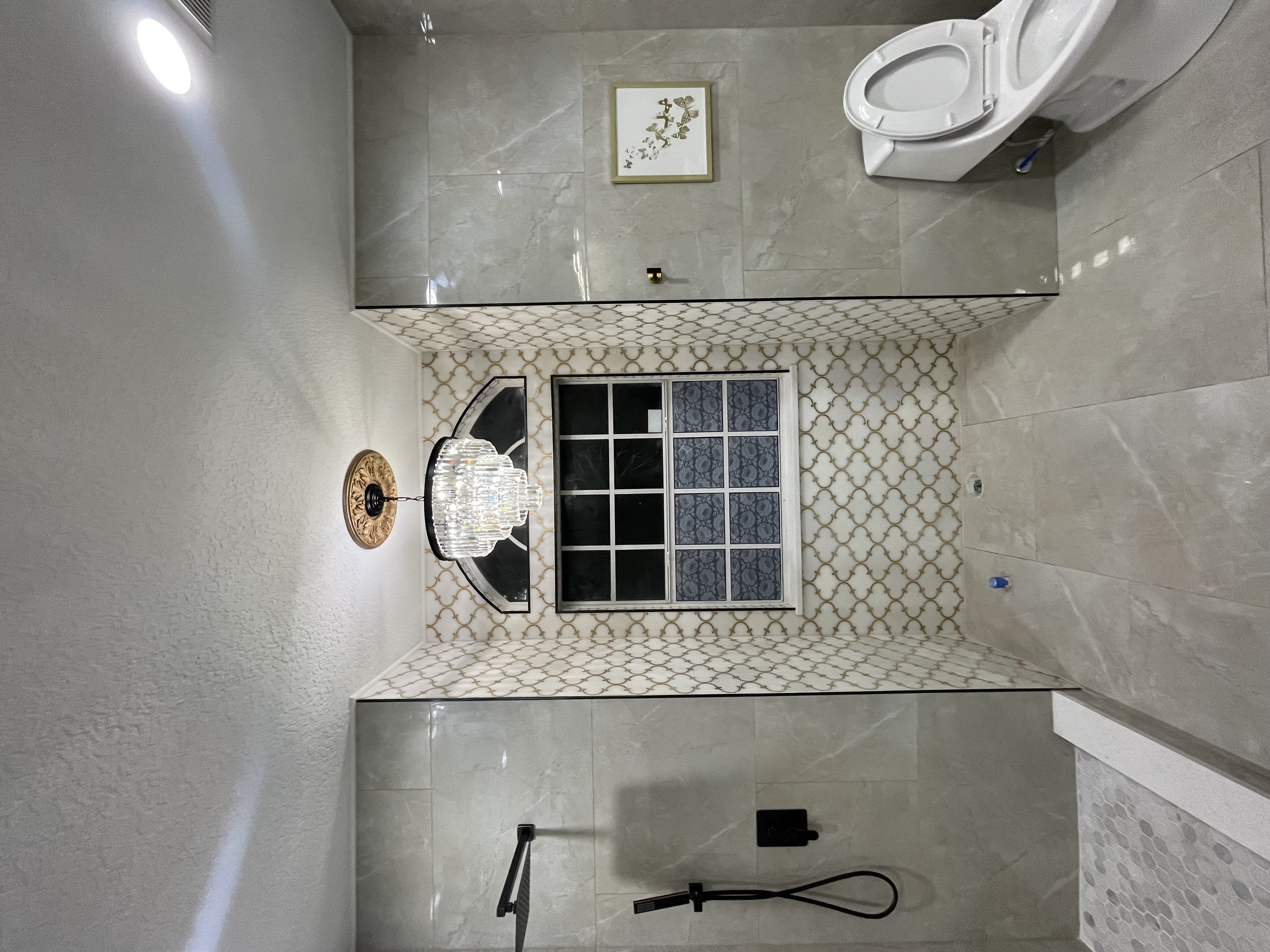 Bathroom with arched tile niche, chandelier, and walk-in shower
