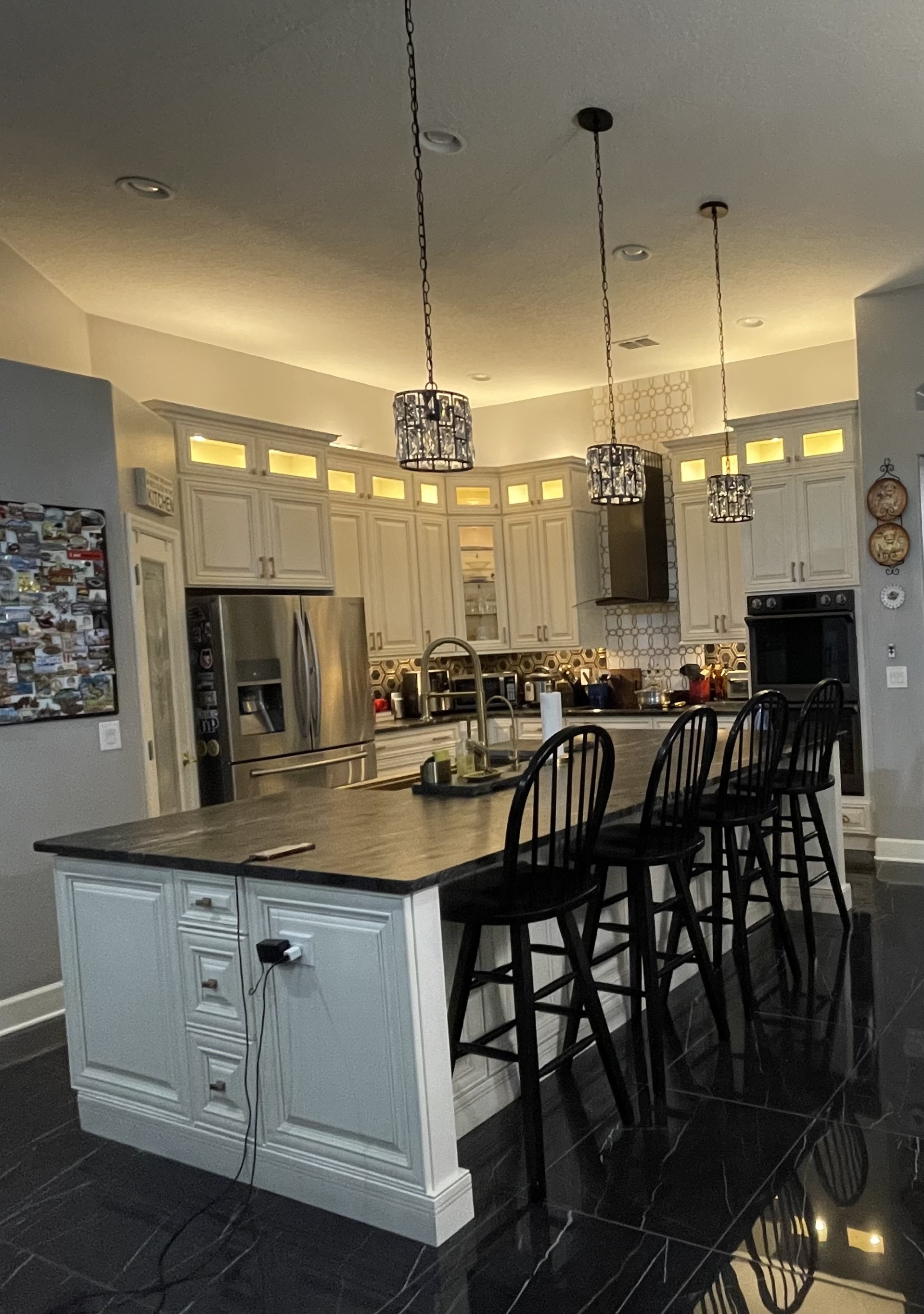 Kitchen remodel with white cabinetry, island seating, and large-format tile flooring