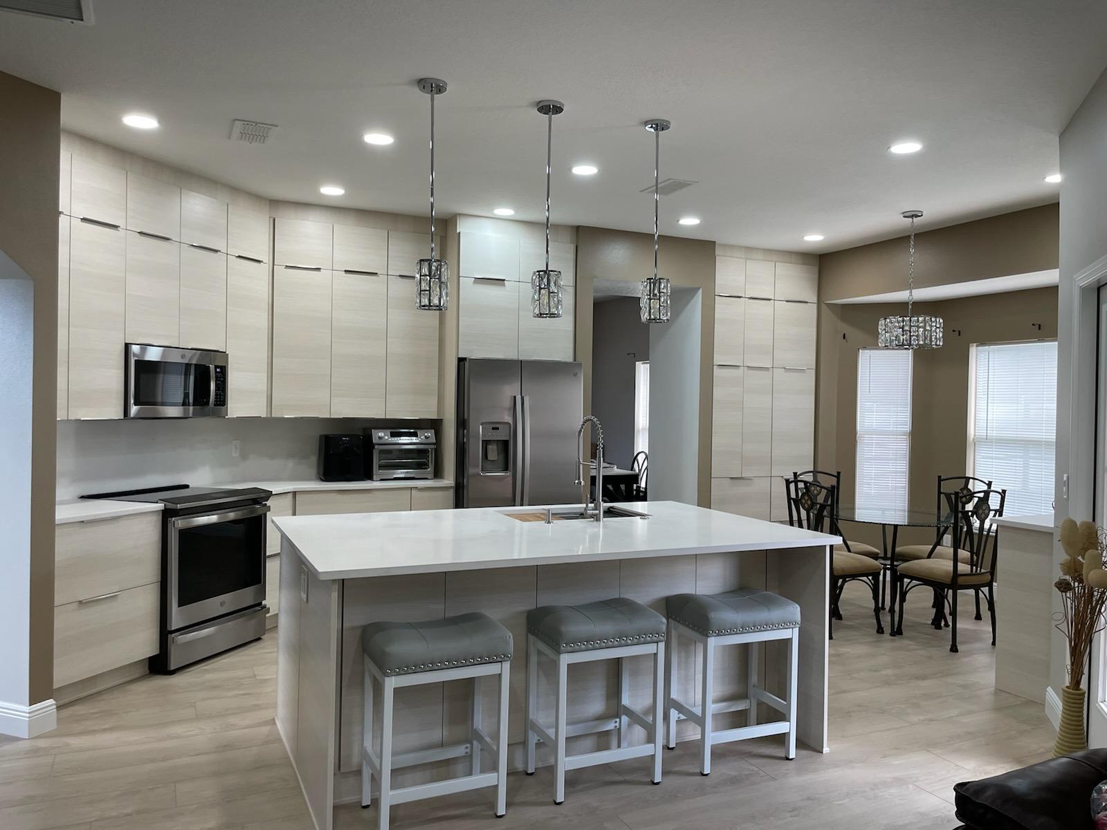 Bright kitchen with custom cabinetry, quartz counters, and wood-look flooring